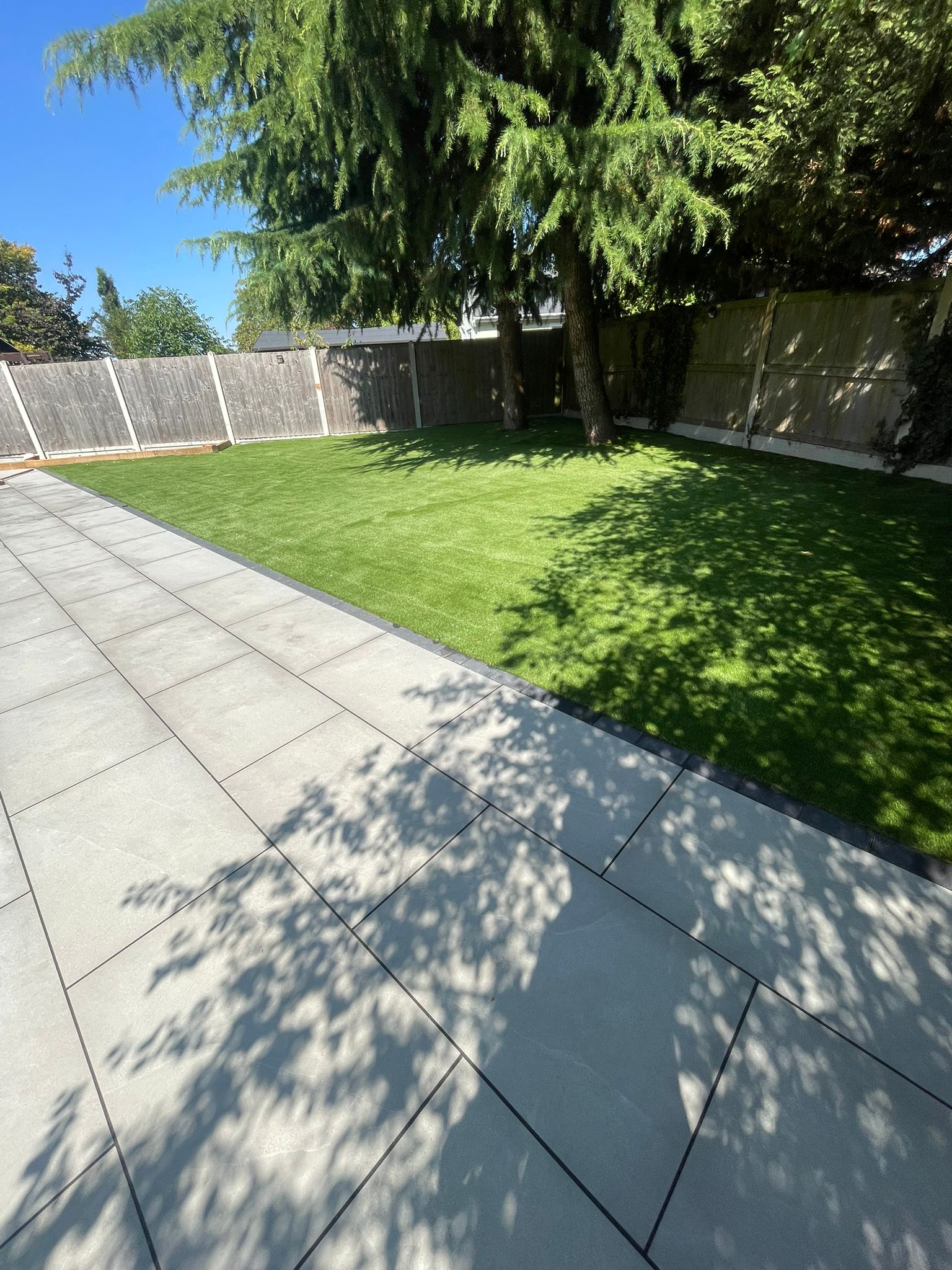 Patio beside artificial lawn & fence